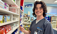A Parrish high school student enrolled at MTC East smiles inside the Pharmacy Tech classroom